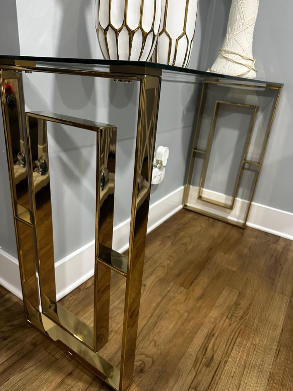 Gold console table with glass top in a room setting
