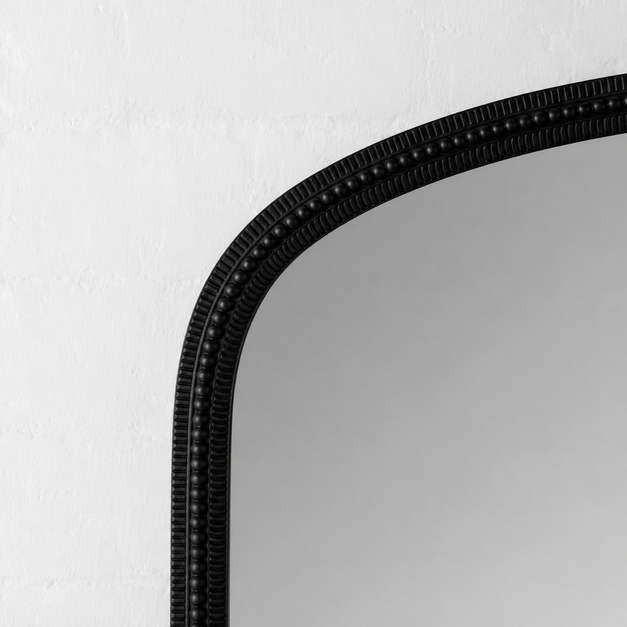 Black-framed mirror on a white wall