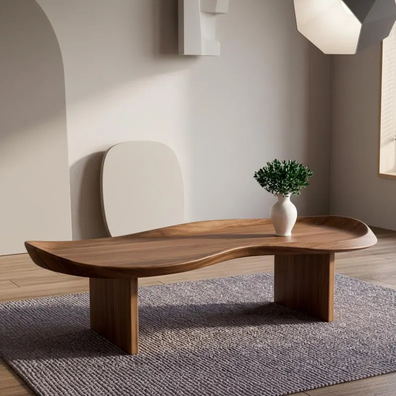 Wooden coffee table with a vase of greenery in a minimalistic room.