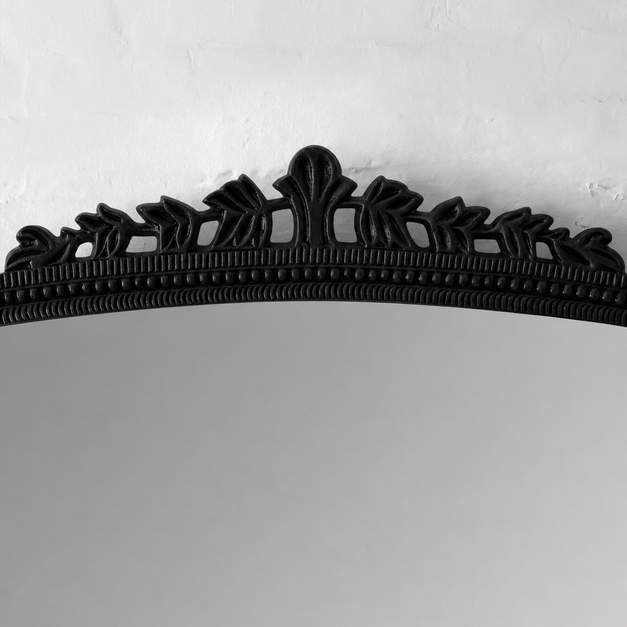 Decorative black metal hanger on a light gray background