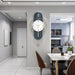Modern wall clock on a gray wall in a home interior setting with a dining area.