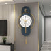 Decorative wall clock with blue and gold accents on a gray wall.
