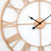 Rose gold wall clock with black hands on a white background