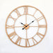 Large round wall clock with rose gold frame and Roman numeral markers on a white background