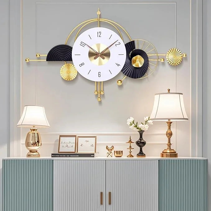 Decorative wall clock with gold and black accents on a light gray wall.