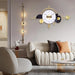 Decorative wall clock in a modern living room setting with a sofa and armchair.