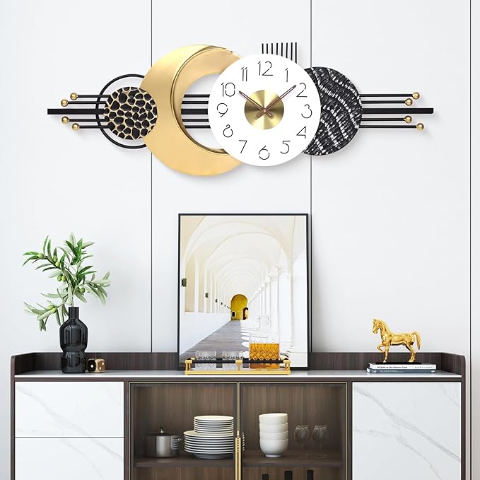 Decorative wall clock with gold and black design on a wall above a cabinet.