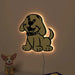 Dog-shaped wall light on a plain wall with a small plush dog toy below.
