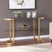 Console table with gold legs and glass shelves in a room setting.