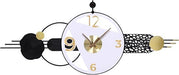 Decorative wall clock with black, gold, and white design elements on a white background
