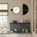 Modern wall clock with black and gold design in a kitchen setting