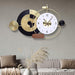 Decorative wall clock with geometric design on a gray wall above a sofa.