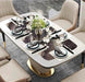 Dining table set with plates, glasses, and silverware on a marble-patterned tablecloth.
