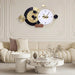 Decorative wall clock with gold and black design in a living room setting.