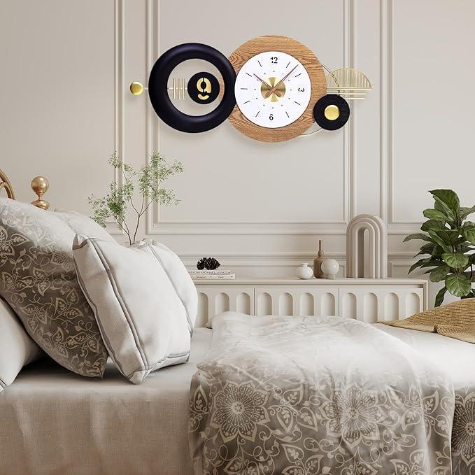 Decorative wall clocks on a neutral wall above a bed with patterned bedding.