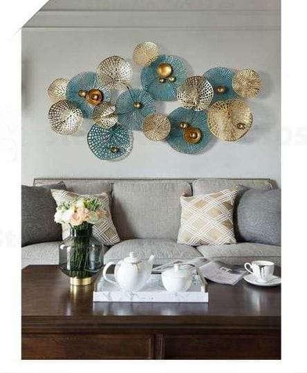 modern metal wallart with teal and gold elements above a gray sofa in a living room.