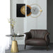 Modern living room with a brown armchair, gold side table, and decorative wall clock.