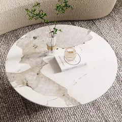 Round marble coffee table with decorative items on a carpeted floor