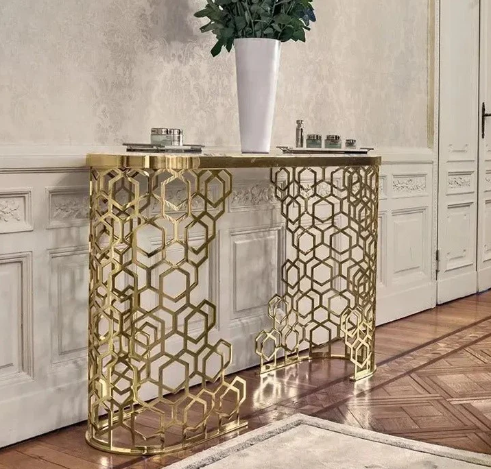 Gold geometric console table in a room with white walls and wooden floor.