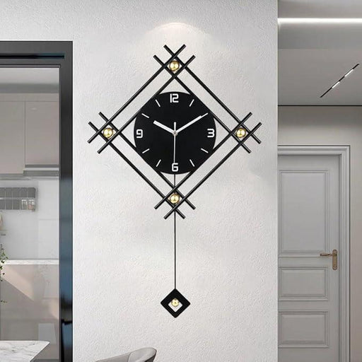 Decorative wall clock with black face and gold accents on a white wall.