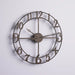 Bronze wall clock with large numbers on a light gray background
