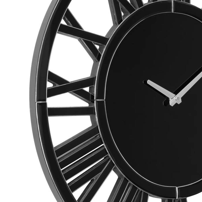 Black wall clock with metallic rim on a white background