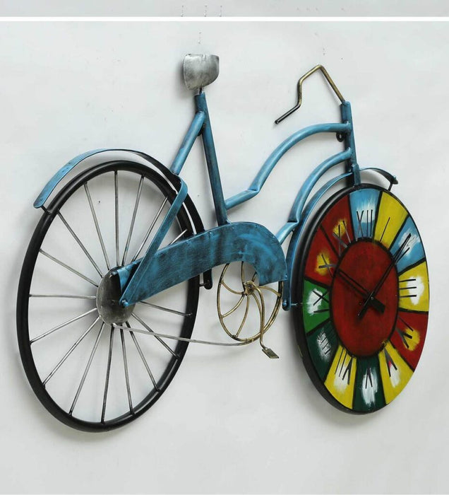Decorative wall clock shaped like a bicycle with a colorful clock face on a white background