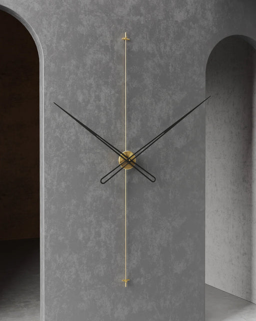 Modern wall clock with gold accents on a gray concrete wall