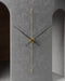 Modern wall clock with gold accents on a gray concrete wall