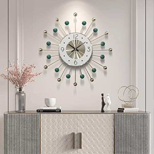 Decorative wall clock with green accents on a wall above a console table.