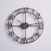 Bronze wall clock with numbers on a light gray background