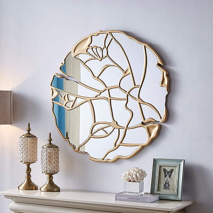 luxury wall mirror with gold leaf design on a white wall above a shelf.
