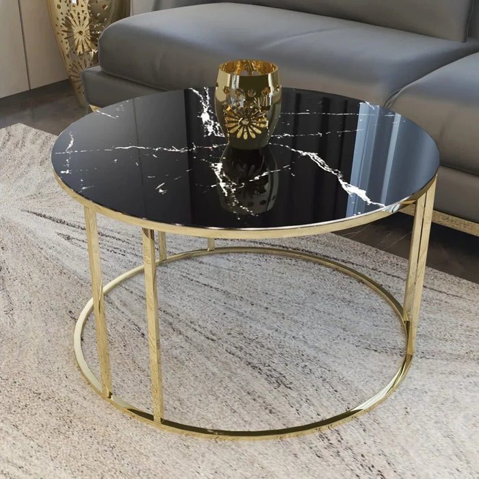 Round black marble coffee table with gold metal base.