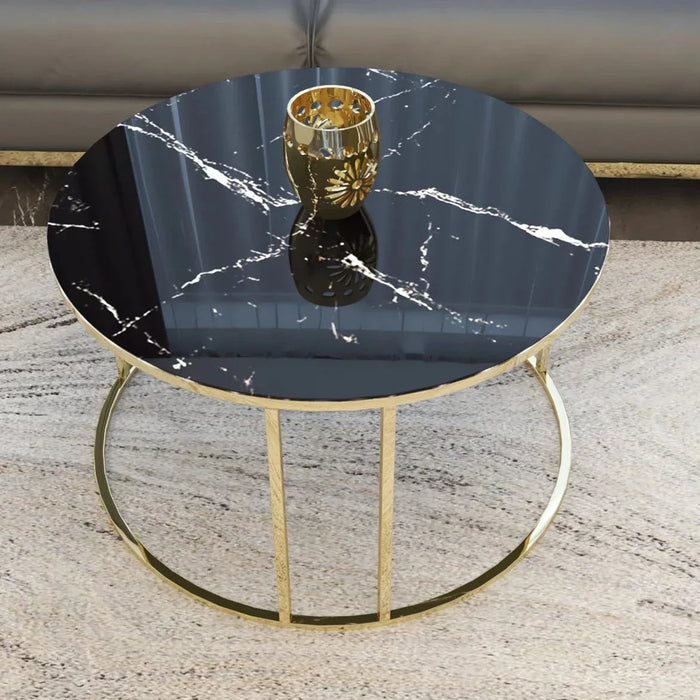 Round marble table with gold base on a textured surface