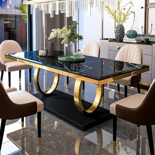 black marble dining table with gold legs and black marble top in a modern kitchen setting.