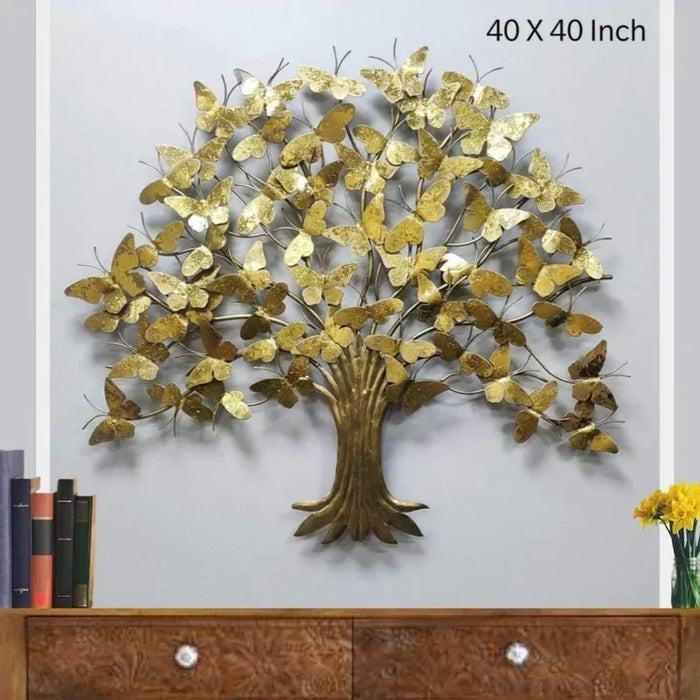 Decorative metal tree wall art with gold leaves on a plain background