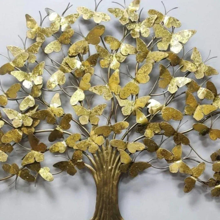 Decorative wall art in the shape of a tree with gold butterflies on a light gray background