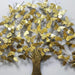 Decorative wall art in the shape of a tree with gold butterflies on a light gray background