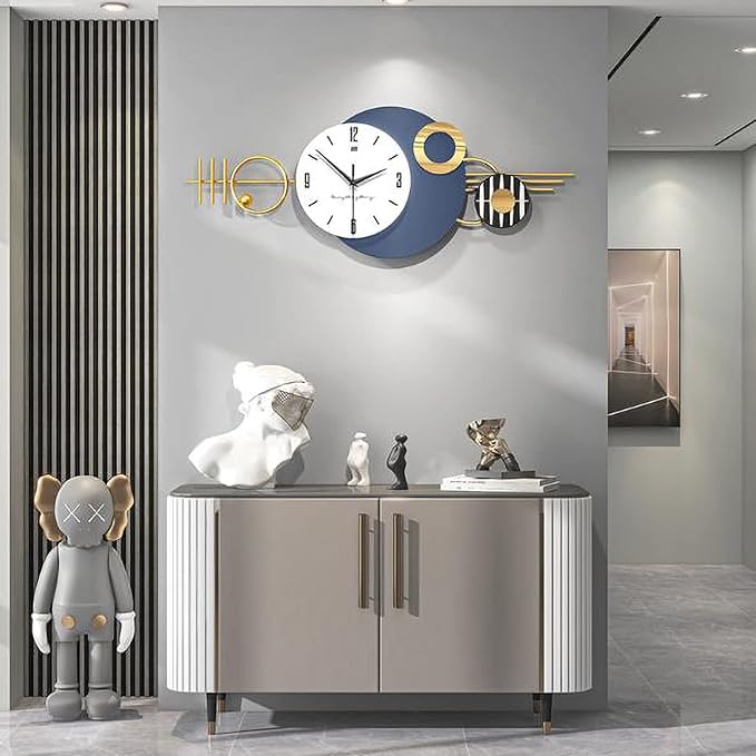 Modern wall clock with decorative elements on a gray wall above a cabinet.