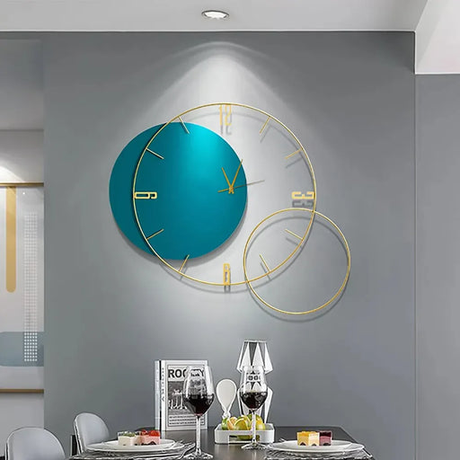 Modern wall clock with teal face and gold accents on a gray wall above a dining table.
