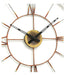 Decorative wall clock with metallic design and black hands on a white background