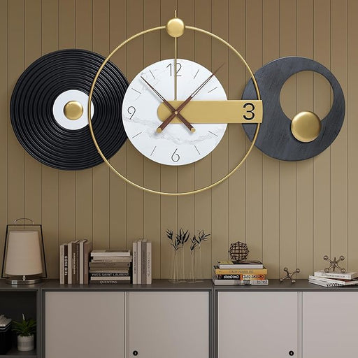 Decorative wall clock with black and gold accents on a wooden wall.