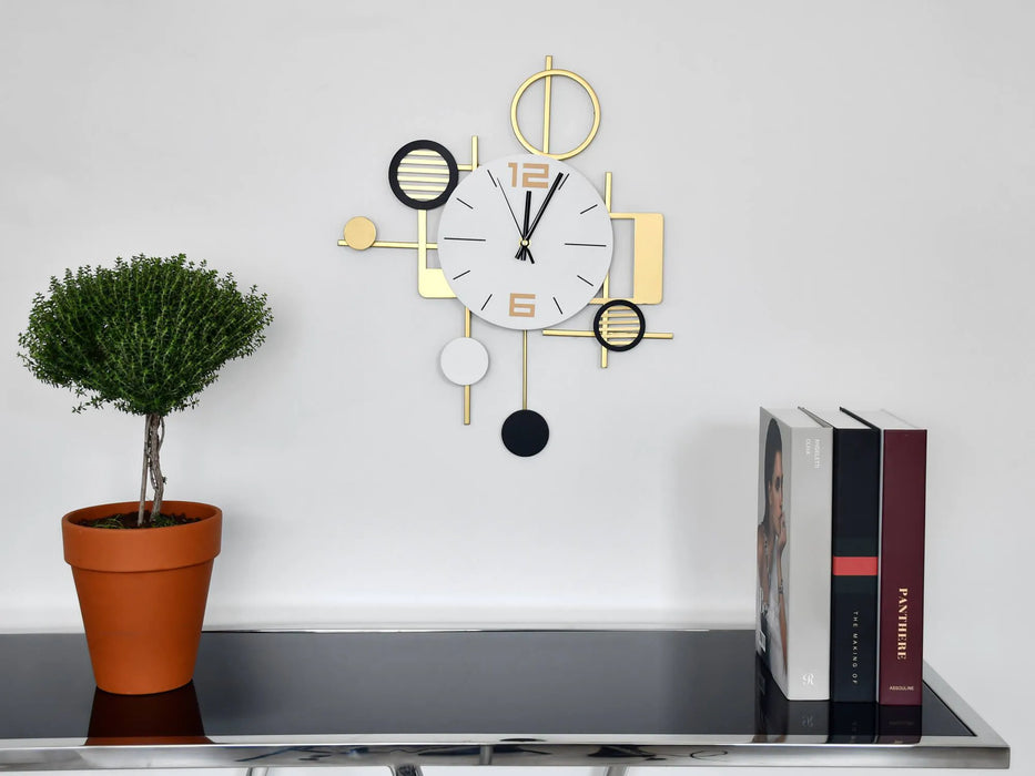 Modern wall clock with decorative elements on a shelf with a plant and books.