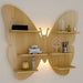 Wooden butterfly-shaped wall shelf with decorative items on a plain background