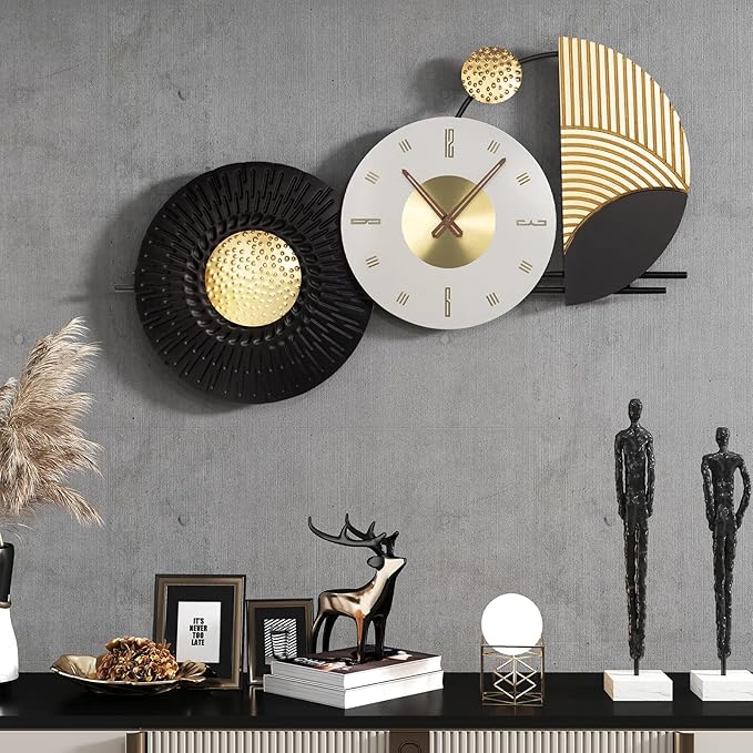 Decorative wall clock with gold and black design on a gray wall with decorative items below.