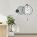 Modern wall clock with decorative elements on a light gray wall.