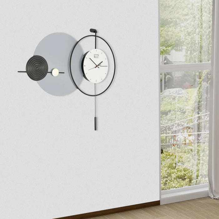 Modern wall clock on a white wall with a view of greenery outside a window.