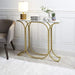 Gold side table with decorative items against a white wall