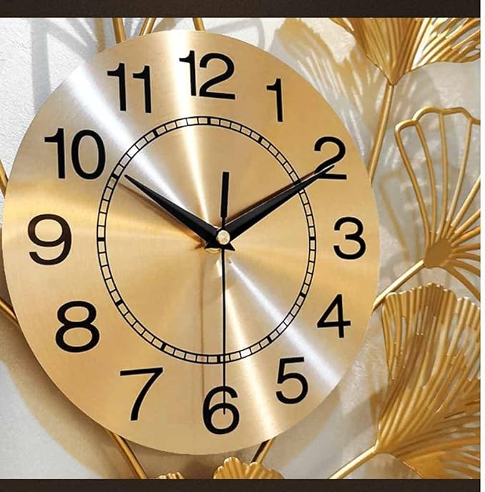 Gold wall clock with decorative elements on a light background