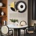 Modern dining room with round table, chairs, and decorative wall clock.